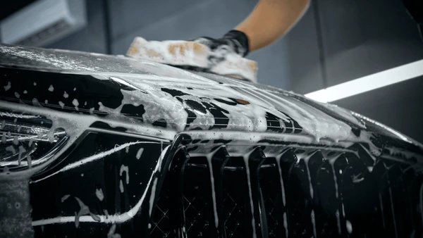Essential detail — hand washing car with foam and sponge